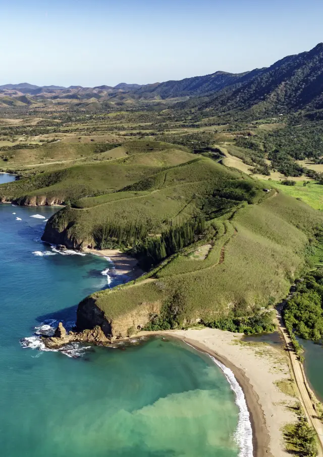 Vue aérienne de la Roche Percée à Bourail, avec sa plage au premier plan, la baie des Tortues et le sentier des Trois Baies.