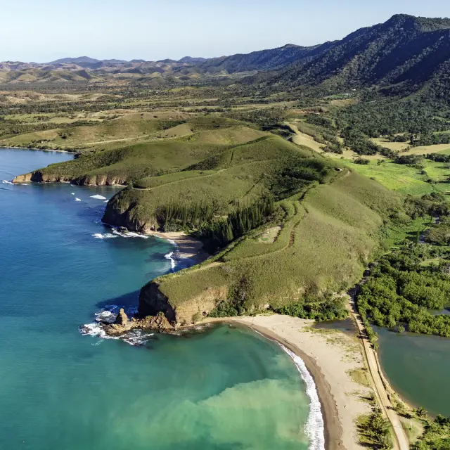 Vue aérienne de la Roche Percée à Bourail, avec sa plage au premier plan, la baie des Tortues et le sentier des Trois Baies.