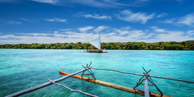 ニューカレドニア、イル・デ・パンのバイ・ドゥピのターコイズブルーのラグーンでの伝統的なピローグでのエクスカーション。