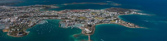 Vue aérienne de l'ensemble de la ville de Nouméa, capitale de la Nouvelle-Calédonie, entouré de ses baies et de son lagon.