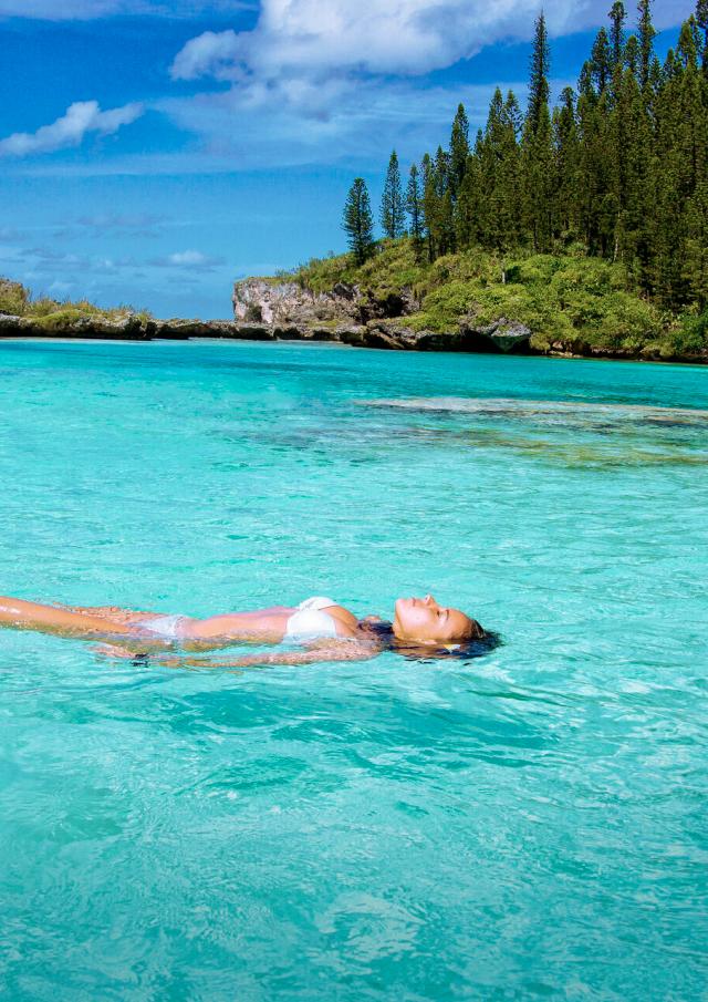 Détente à la Piscine naturelle d'Oro et son eau cristalline, entourée des pins colonnaires à l'Île des Pins, en Nouvelle-Calédonie.