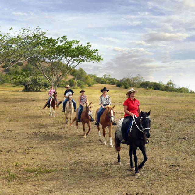 Groupe de touristes faisant une randonnée équestre sur une proprité de Koumac.