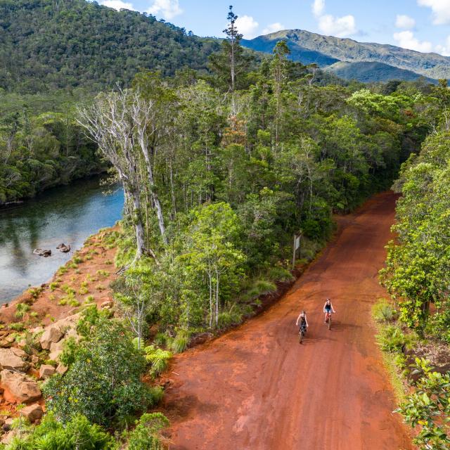 Mountain biking near a river in the Rivière Bleue Provincial Park in Yaté, in the Grand Sud of New Caledonia.