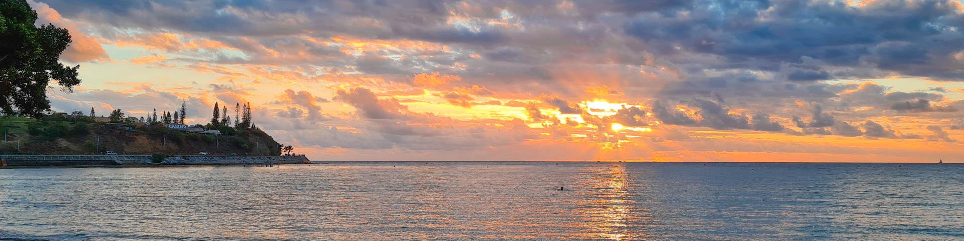 Coucher du soleil sur la plage de la Baie des Citrons à Nouméa, en Nouvelle-Calédonie.