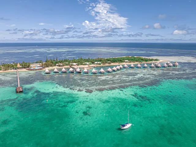 Aerial view of DoubleTree by Hilton at Îlot Maître, with its overwater bungalows above the lagoon near Nouméa.