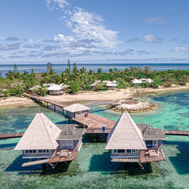 Vue aérienne sur l'hôtel DoubleTree by Hilton Îlot Maître Resort et ses bungalows sur pilotis à Nouméa en Nouvelle-Calédonie.