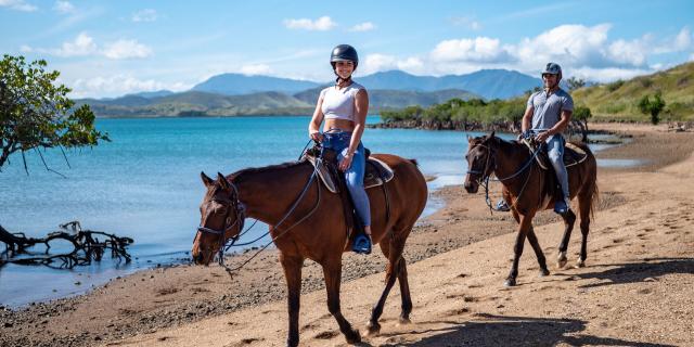 Horseback riding on the beach of Islet Puen in Boulouparis, New Caledonia.