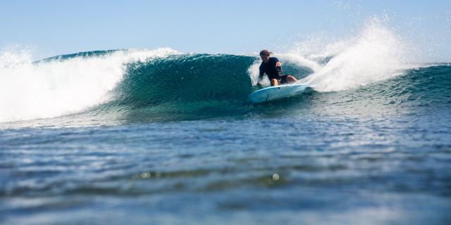 Surf session on the Bourail coral reef near the Roche Percée beach.