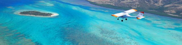 Microlight flight over the lagoon and Île Verte in Bourail, New Caledonia.