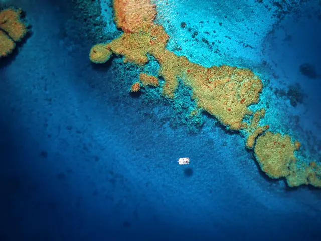 Vue aérienne d’un catamaran sur le lagon bleu, près des récifs coralliens aux alentours de Hienghène, en Nouvelle-Calédonie.
