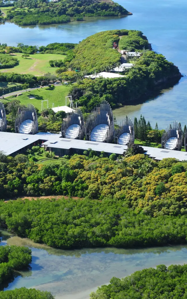 Vue aérienne du Centre culturel Tjibaou à Nouméa, entre mangrove, végétation tropicale et lagon.