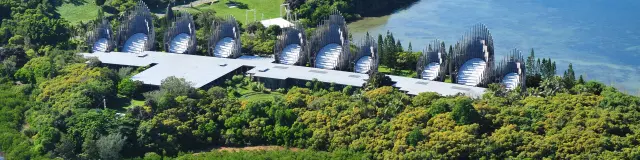 Aerial view of the Tjibaou Cultural Centre in Nouméa, set between mangroves, tropical vegetation and the lagoon.