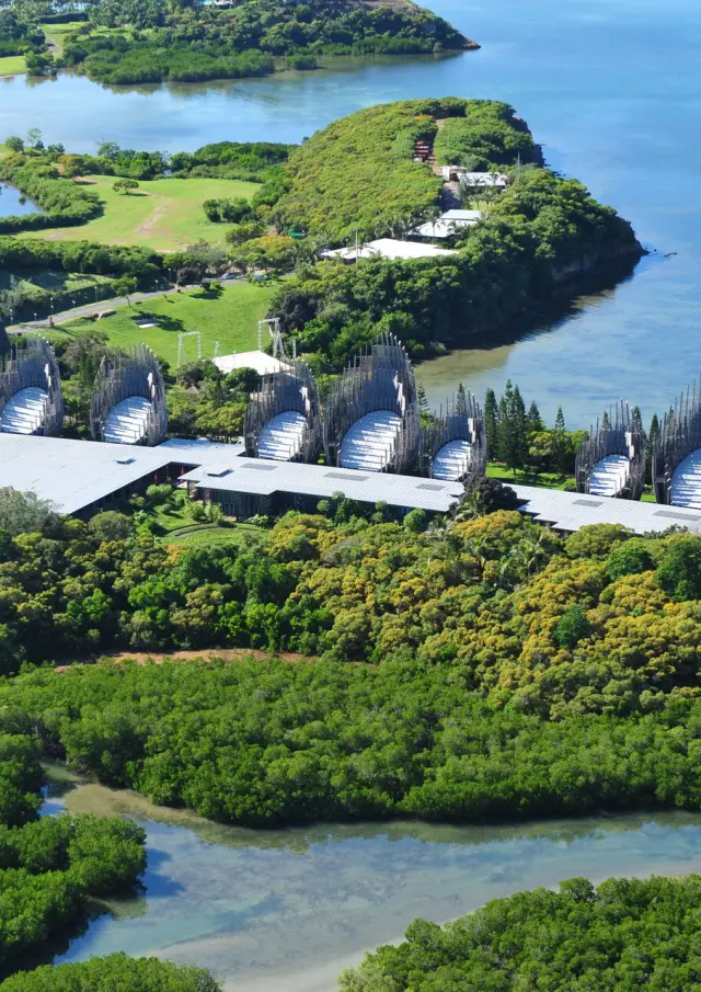 Vue aérienne du Centre culturel Tjibaou à Nouméa, entre mangrove, végétation tropicale et lagon.