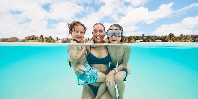 Family swimming in the Ouvéa lagoon