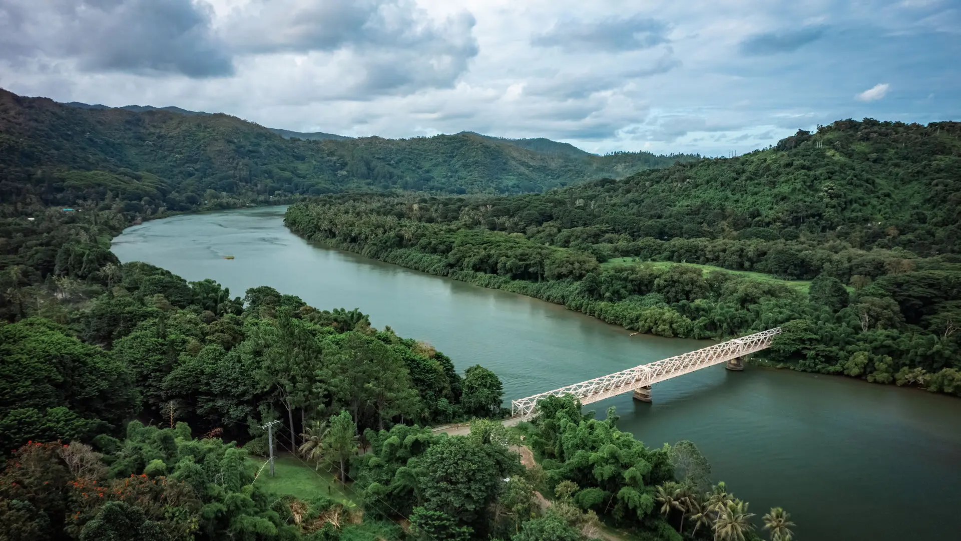 Vue aérienne du pont Eiffel à Ponérihouen, traversant une rivière entourée de forêt tropicale, en Nouvelle-Calédonie.