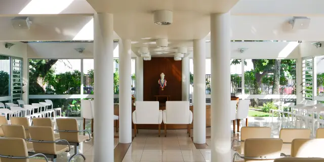 Bright wedding room at Nouméa City Hall, with rows of seats, chairs for the couple and a republican bust at the back.