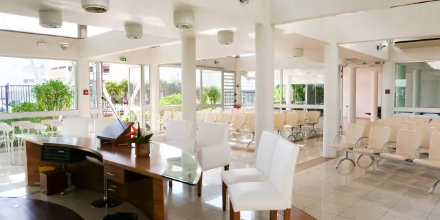 Bright wedding room at Nouméa City Hall, with an official desk, white chairs and rows of seats for guests.