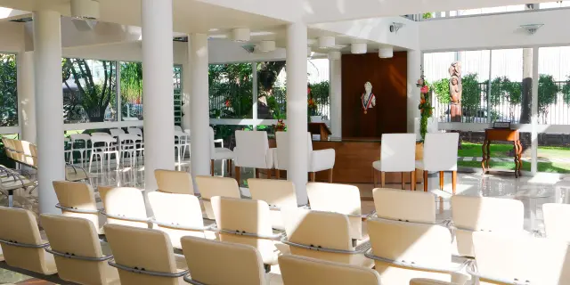 Bright wedding room at Nouméa City Hall, with rows of seats, chairs for the couple and the official ceremony area at the back.