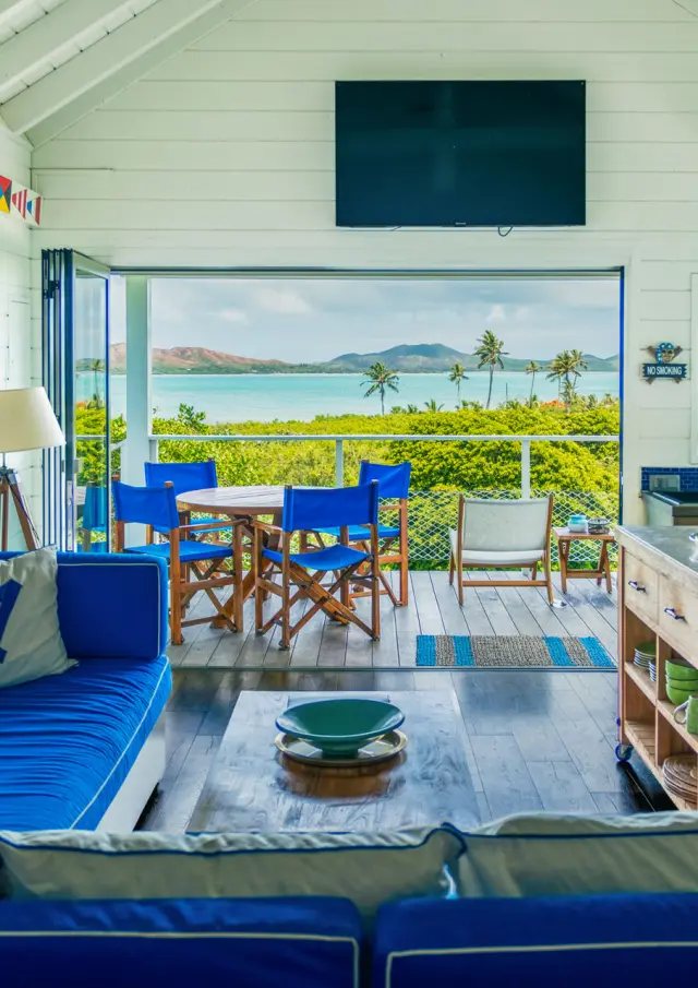 Vue intérieure d’une villa du Beach House Lodge à Poum, avec salon, cuisine ouverte et terrasse donnant sur le lagon.