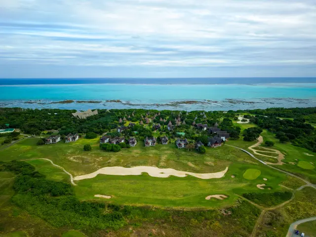 Aerial view of New Caledonia Deva Spa & Golf Resort in Bourail, with the golf course, bungalows and Poé Lagoon in the background.